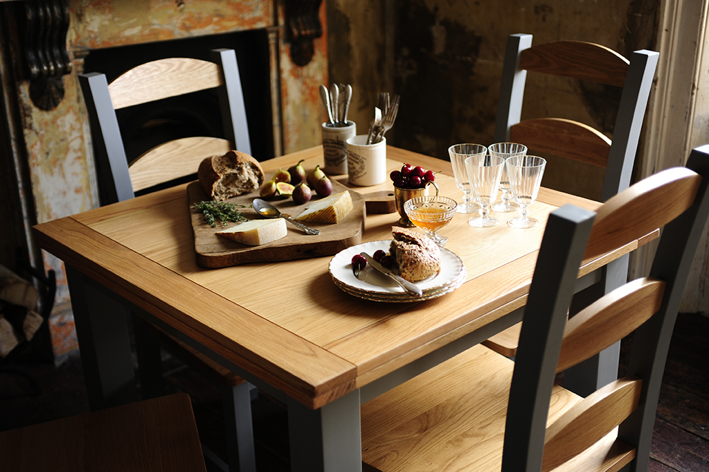 Dining table, bread, figs, fruit, glasses, cutlery, honey, cherries, cheese, breadboard, rustic