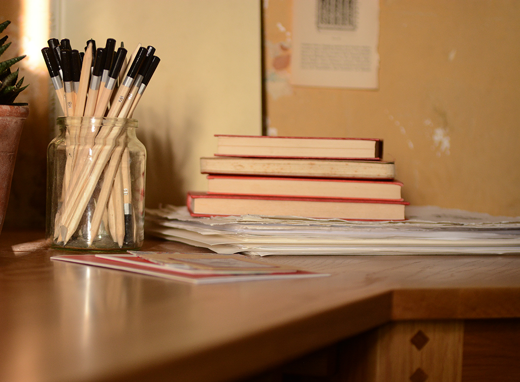 Oak desk, home office, pencils, books, paper