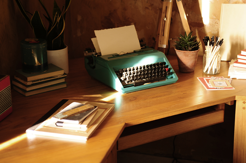Oak desk, home office, typewriter, pencils, notepads