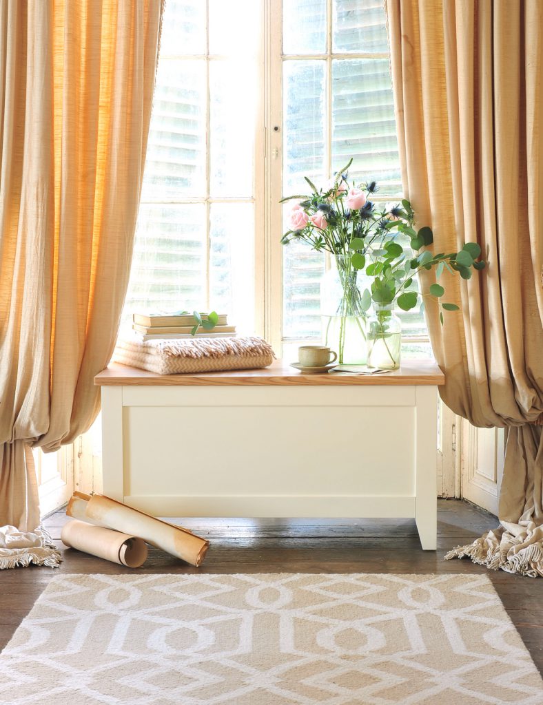Blanket box, geometric rug, flowers, vintage curtains
