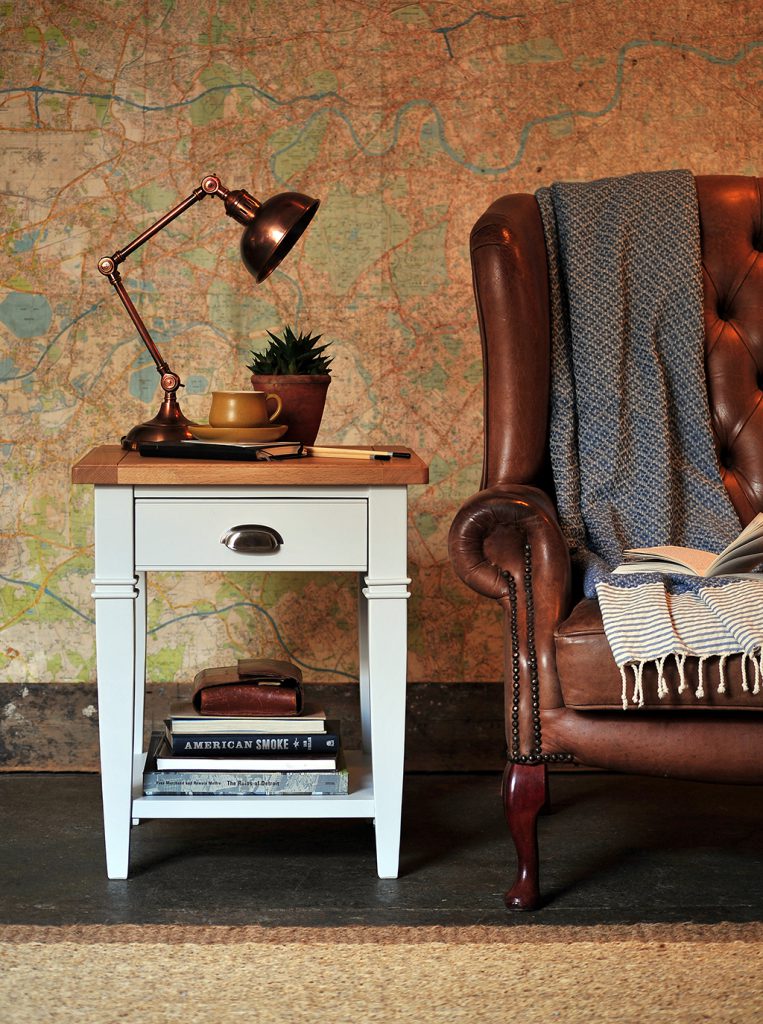 Grey lamp table, leather chair, books, copper lamp, vintage map