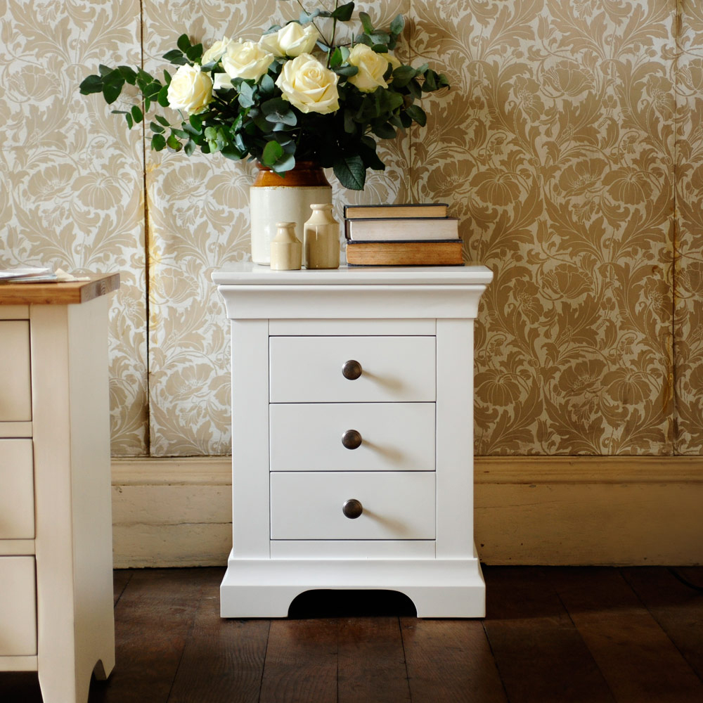 White bedside table, white furniture, vintage wallpaper, books, earthernware, roses