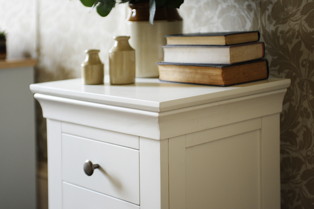 White bedside table, white furniture, vintage wallpaper, books, earthernware