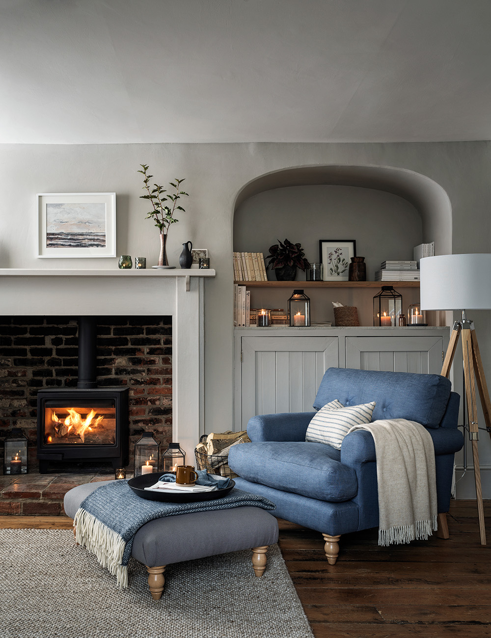 how to prepare home for guests at Christmas time, blue armchair, cosy fireplace, living room, footstool, cashmere throw, tea tray, candles, alcove, grey living room
