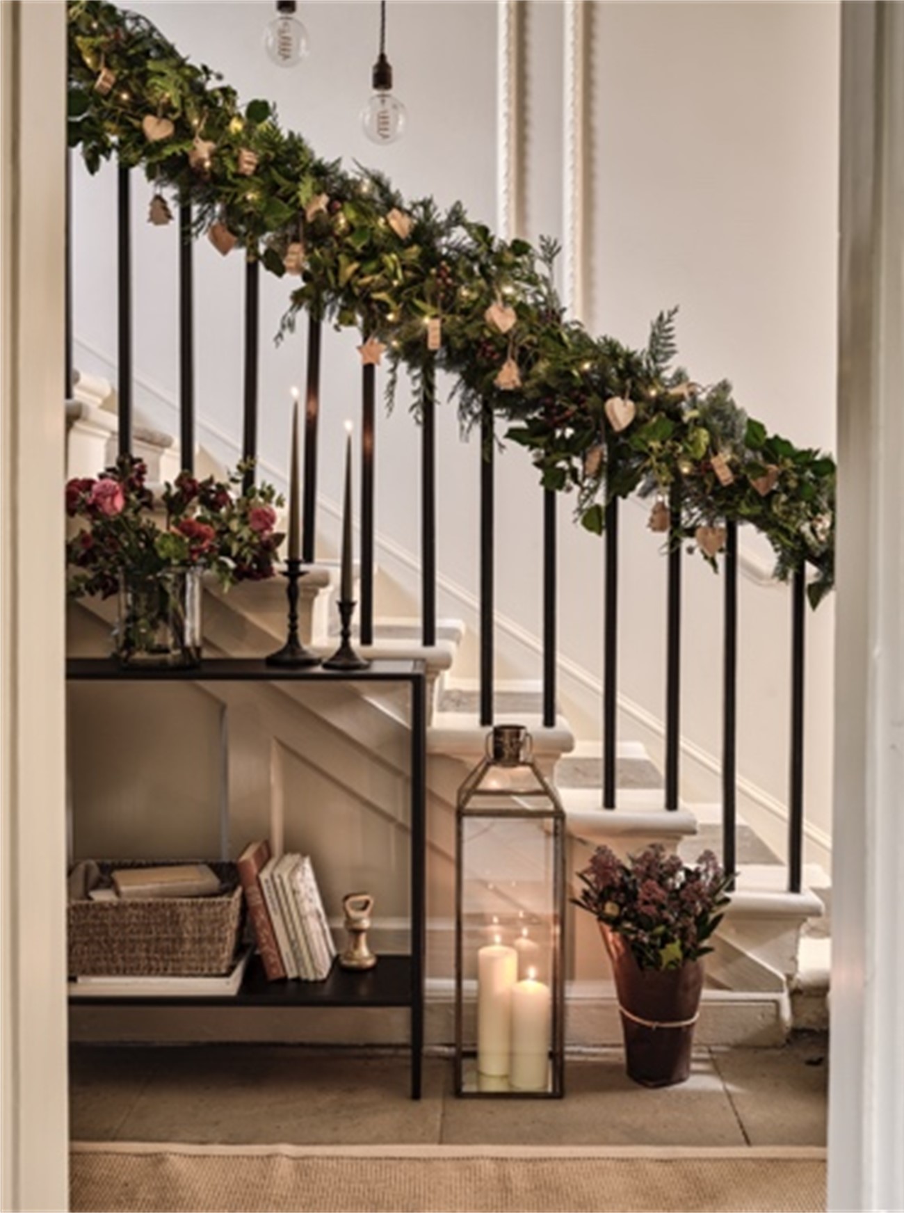 festive hallway, prepare home for guests, warm welcome, christmas garland, stairwell, banister, console table, the cotswold company